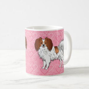 Glücklicher roter und weißer Phalène-Hund auf rosa Kaffeetasse