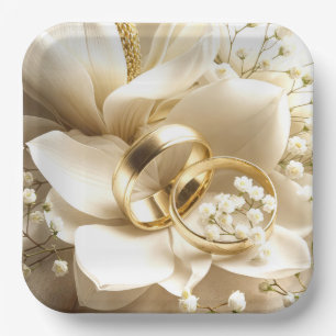 Gold Wedding Bands auf einer Magnolia Blume Pappteller