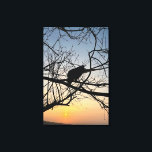 Golden Sunset Silhouette: Bird on Tree Branches Leinwanddruck<br><div class="desc">Capture the serene beauty of twilight with this stunning silhouette photograph. A lone bird rests among the intricate web of bare tree branches, set against a vibrant golden and blue sunset sky. The high contrast and natural geometry create a peaceful, artistic atmosphere that complements any modern decor. This design is...</div>