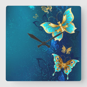 Goldene Schmetterlinge auf einem blauen Hintergrun Quadratische Wanduhr