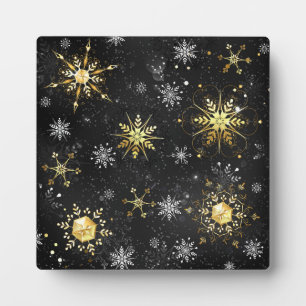 Goldene Schneeflocken auf schwarzem Hintergrund Fotoplatte