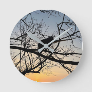 Goldene Sonnenuntergangs-Silhouette: Vogel auf Bau Runde Wanduhr