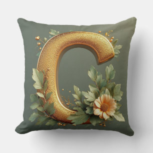 Goldener Buchstabe C umgeben von floralen Arrangem Kissen
