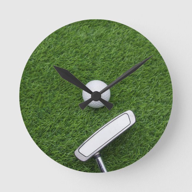 Golf ball with putter are on green grass runde wanduhr (Vorderseite)