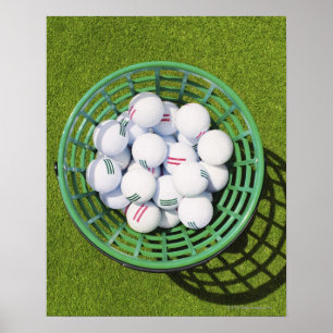 Golfbälle in einem Korb, der auf kurzem Grün sit Poster