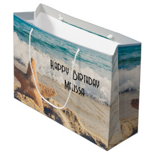 Grand Sac Cadeau Starfish sur une plage de sable Photo