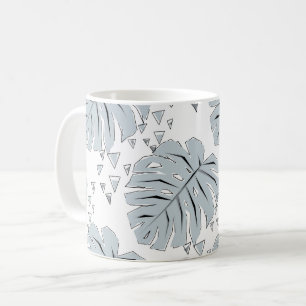 Graue Monstera-Blätter auf weiß Kaffeetasse