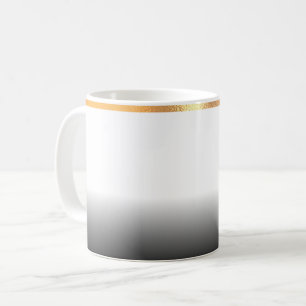 Graue und goldgeriebene Tasse