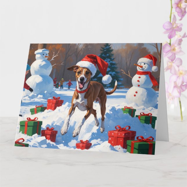 Greyhound läuft im Schnee mit Weihnachtshut Karte (Orchidee)
