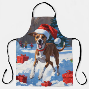 Greyhound läuft im Schnee mit Weihnachtshut Schürze