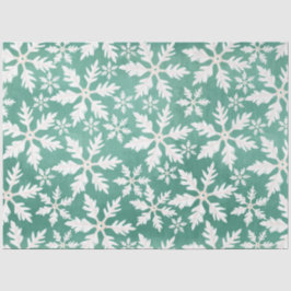 Große weiße Schneeflocken fallen ins Grüne Seidenpapier