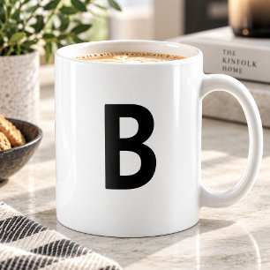 Großer schwarzer Anfangsbuchstabe minimalistisches Kaffeetasse