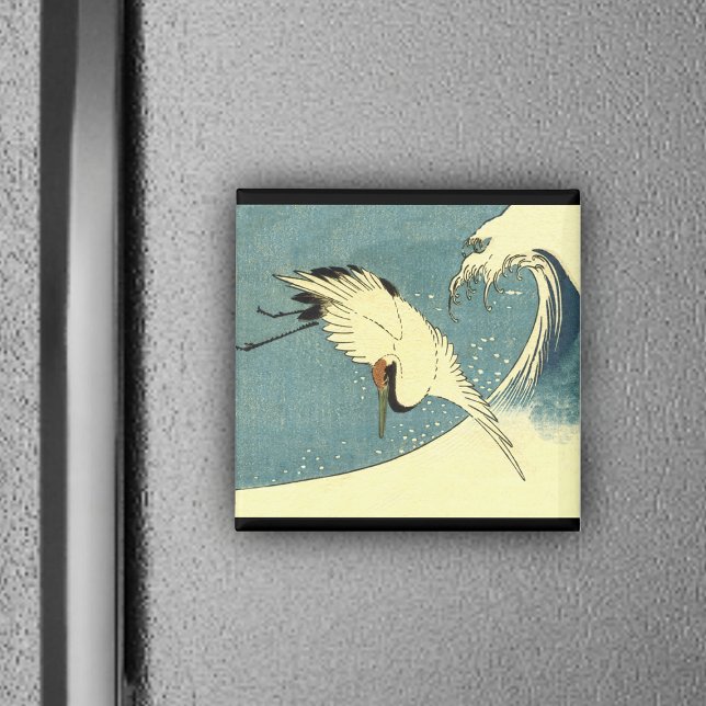 Grue volant dans un aimant à vague (White crane bird flying over blue ocean wave black borders on magnet.)
