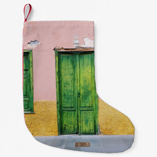 GRÜNE HOLZTÜR AN DER WEISSEN KONKRETEN WAND KLEINER WEIHNACHTSSTRUMPF