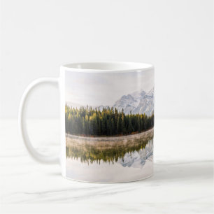 GRÜNE PINENBÄUME AM WASSERKÖRPER WÄHREND DES TAYTI KAFFEETASSE