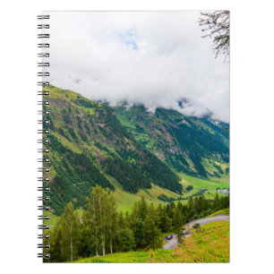 Grüne, waldbedeckte Berge und grünes Gras Notizblock