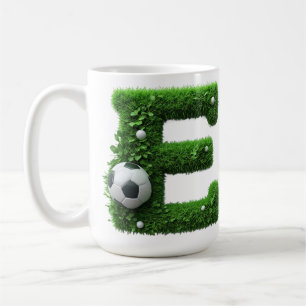 Grüner Gras-Buchstabe E-Topiarie mit Fußball Kaffeetasse