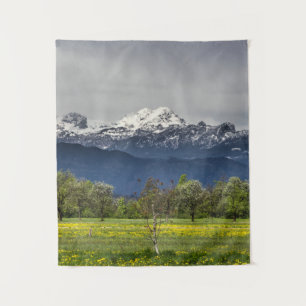Grünes Feld mit schneebedeckten Alpen Wandteppich