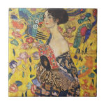 Gustav Klimt Lady mit Fan Art Nouveau Malerei Fliese<br><div class="desc">Gustav Klimt Lady mit Fan Art Nouveau Malerei Dieses Halbportrait einer schönen Frau zeigt einen gelben Hintergrund mit asiatischen Ornamenten, bunten Vögeln und Lotus Blume. Die Dame trägt ein Kleid im Stil eines Kimono, das mit Motiven eines chinesischen Drachenkleides bedruckt ist. Schöne künstlerisch romantische dekorative Kunstmalerei. Weitere Geschenke von Gustav...</div>