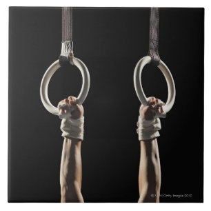 Gymnast, der von Ringen 2 schwingt Fliese