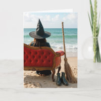 Halloween Hexe sitzt auf einem Sofa an der Küste