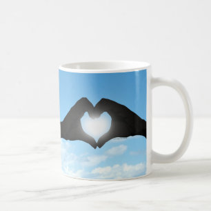 Hände in der Herz-Form-Silhouette auf blauem Kaffeetasse