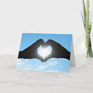 Hände in Herzform-Silhouette vor blauem Himmel Karte