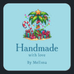 Handgefertigt mit Liebe Tropical Christmas Palm Tr Quadratischer Aufkleber<br><div class="desc">Handgefertigt mit Liebe-Aufklebern mit saisonalem Urlaubsimage. Eine tropische Palme,  die mit festlichen Lichtern dekoriert ist und auf der ein Stern steht. Ein riesiger,  rot-weißer Bonbons,  der aus dem Sand ragt. Weihnachten präsentiert sich unter dem Baum. Whimsical und lustig.</div>