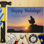 Happy Holidays Custom Construction Company Sunset Postkarte<br><div class="desc">Ein Bauarbeiter kröpft vor einem schönen Sonnenuntergang auf dieser schönen Happy Holidays Postkarte. Eine niedliche personalisierte Baufirma oder Zuhause-Erbauer Geschäft Weihnachtspostkarte.</div>
