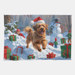 Havanese läuft im Schnee mit Weihnachtsmütze Geschirrtuch