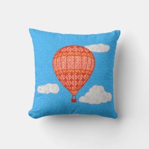 Heißluftballon, Korallenorange gegen einen blauen  Kissen