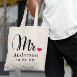 Herr Elegant Script Heart Custom Wedding Monogram Tragetasche<br><div class="desc">Personalisierte Mr. tote Tasche für den neu verheirateten Bräutigam mit elegantem,  modernem,  schwarzem Drehbuch und klassischem Familienname und Hochzeitstermin-Monogramm-Text,  der personalisiert werden kann. Das Design umfasst ein niedliches,  rotes Herzstück. Ein tolles Hochzeitsgeschenk für die Flitterwochen! Laden Sie unser Geschäft für die koordinierende Frau Tasche Design.</div>