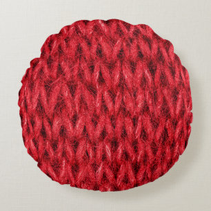 Hintergrund aus roter Strickwolle. Rundes Kissen