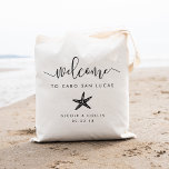 Hochzeit in Urlaubsort Begrüßungsbeutel | Starfish Tragetasche<br><div class="desc">Herzlich willkommen in Ihrer Hochzeit in Urlaubsort mit diesen schicken und modernen personalisierten Taschen. Design-Funktionen "willkommen" in modernen handgeschriebenen Kalligraphie-Skripten,  mit Platz,  um mit Ihrem Hochzeitort,  Namen und Datum personalisieren. Eine Silhouette mit tropischen Seestern rundet das Design ab.</div>