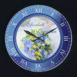 Hochzeitstag-blauer Saphir-römische Ziffern Große Wanduhr<br><div class="desc">Eine reizende Uhr in den blauen Saphirtönen, mit römischen Ziffern. Der Rahmen, der als Teil der Uhr arbeitet, ist auch ein Rahmen für Ihre Lieblingshochzeitsphotographie. Behalten Sie das Beispielbild des Blumenblumenstraußes des blauen, gelben und grünen Frühlinges, oder ersetzen Sie es durch Ihr eigenes Bild für volle Personifizierung. Addieren Sie Ihre...</div>