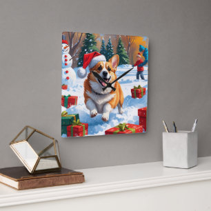 Horloge Carrée Corgi courant dans la neige avec un chapeau de Noë