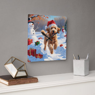 Horloge Carrée Goldendoodle courant dans la neige avec un chapeau