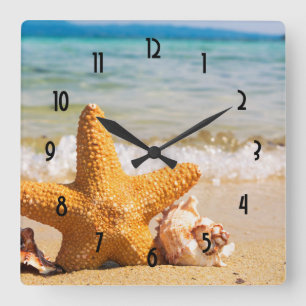 Horloge Carrée Poisson étoilé et coquillages sur la plage