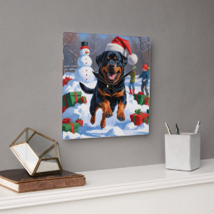 Horloge Carrée Rottweiler courant dans la neige avec un chapeau d