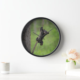 Horloge Jeune ours noir jouant sur une branche d'arbre