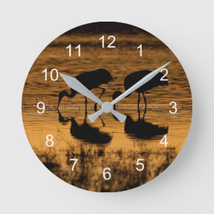 Horloge Ronde Grues Silhouettées par le coucher du soleil