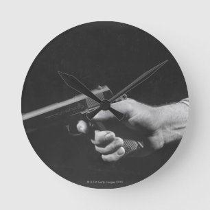Horloge Ronde Homme tenant l'arme à feu