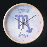 Hübsches Skorpio Astrologie Signieren Personalisie Uhr<br><div class="desc">Diese hübsche lila und lavendere Scorpio Uhr zeigt Ihr astrologisches Zeichen aus dem Zodiac in einem schönen Funkeln wie die Sternbilder. Passen Sie dieses niedliche Geschenk mit Ihrem Namen in kursiver Schrift für jemanden mit einem Geburtstag Ende Oktober oder Anfang November Geburtstag an.</div>