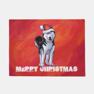 Husky in Weihnachtsmannmütze auf Rot Fußmatte