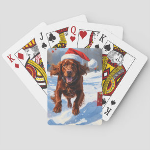 Irish Red Setter läuft durch Schnee mit Weihnachts Spielkarten