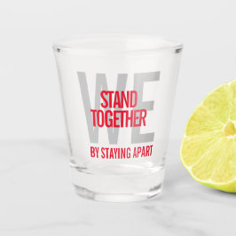 Ironisch stehen wir zusammen, indem wir voneinande schnapsglas