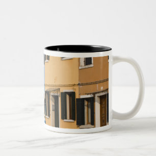 Italien, Burano. Bunte Häuserreihe und leere Zweifarbige Tasse