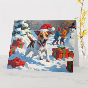 Jack Russell läuft im Schnee mit Weihnachtsmütze Karte