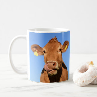 Jersey-Kuh, die seine Nase leckt Kaffeetasse
