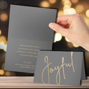 Joie dorée sur carte de Noël grise pliée